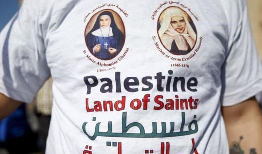 حمل الحضور الأعلام الفلسطينية إلى جانب أعلام الفاتيكان حمل الحضور الأعلام الفلسطينية إلى جانب أعلام الفاتيكان