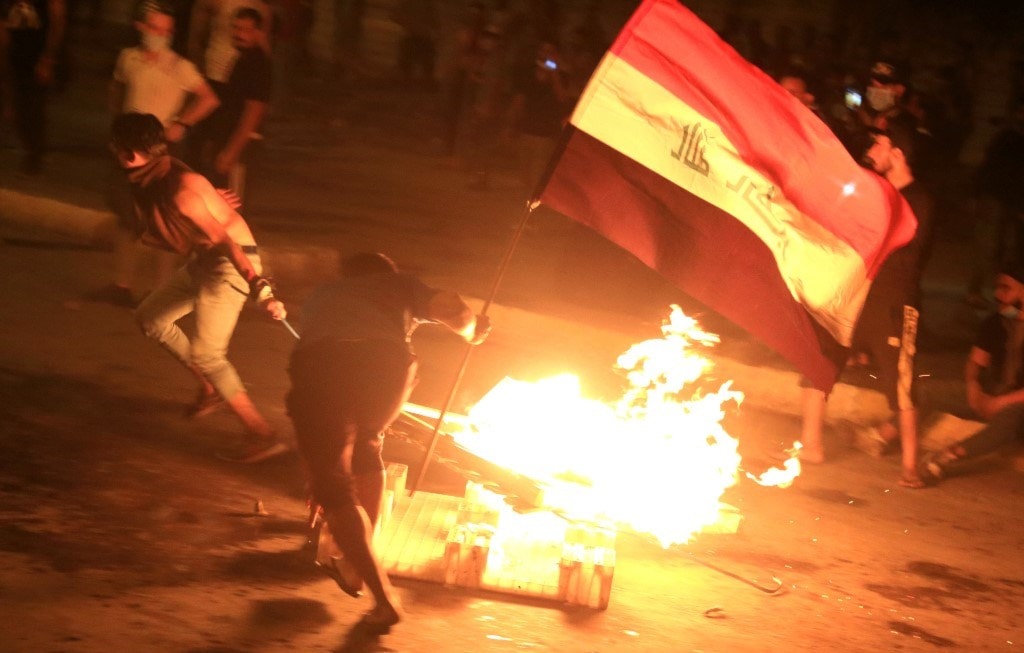 متظاهرون عراقيون يحاولون إغلاق إحدى الطرقات في العاصمة بغداد أمس الأحد (أ.ف.ب) متظاهرون عراقيون يحاولون إغلاق إحدى الطرقات في العاصمة بغداد أمس الأحد (أ.ف.ب)