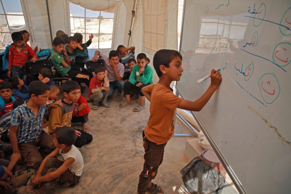 طفل يكتب على لوح داخل خيمة لليونيسف تحوّلت إلى مدرسة في إدلب / أ.ف.ب طفل يكتب على لوح داخل خيمة لليونيسف تحوّلت إلى مدرسة في إدلب / أ.ف.ب