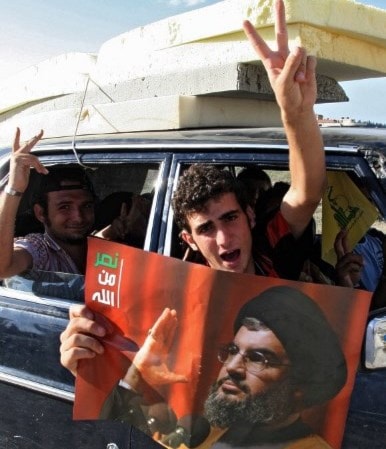 لبنانيون يرفعون شارة النصر وصورة السيد نصر الله خلال عودتهم إلى منازلهم بعد نصر تموز 2006 / أ.ف.ب لبنانيون يرفعون شارة النصر وصورة السيد نصر الله خلال عودتهم إلى منازلهم بعد نصر تموز 2006 / أ.ف.ب