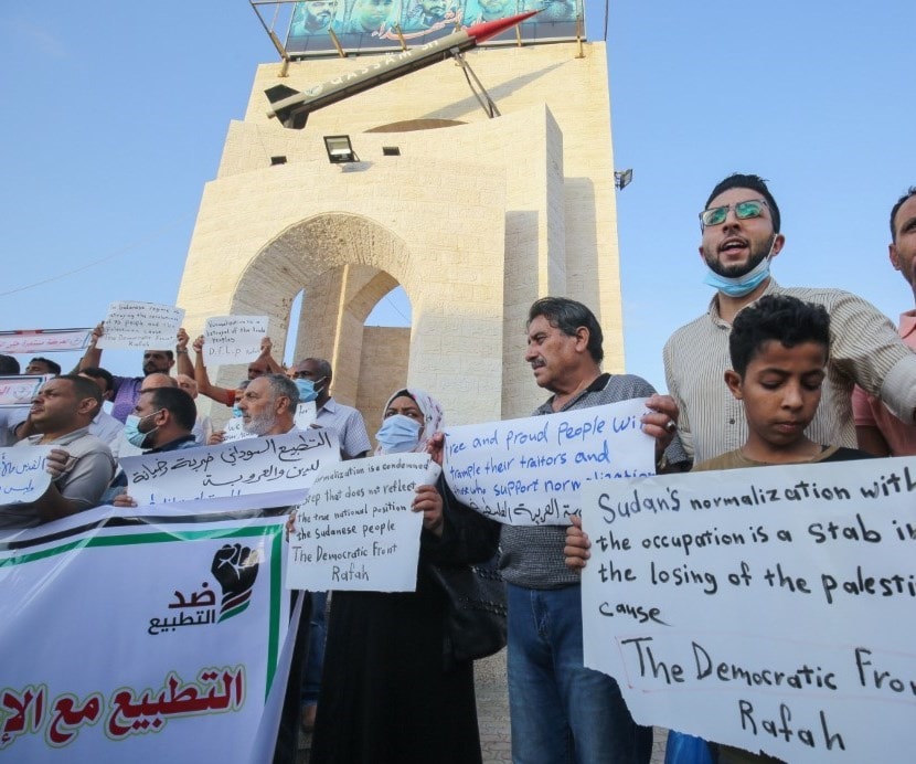 متظاهرون فلسطينيون يرفعون لافتات احتجاجا على اتفاق تطبيع السودان مع "إسرائيل"، في غزة (أ ف ب) متظاهرون فلسطينيون يرفعون لافتات احتجاجا على اتفاق تطبيع السودان مع "إسرائيل"، في غزة (أ ف ب)