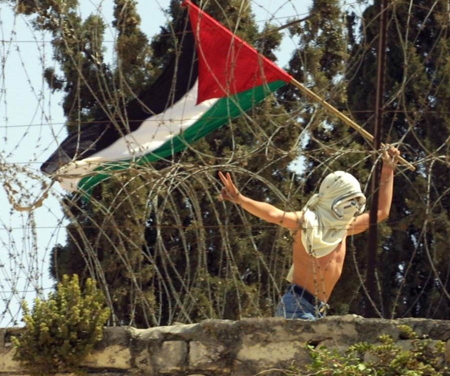 شاب يحمل العلم الفلسطيني ويرفع علامة النصر قرب المسجد الأقصى خلال اشتباكات مع الاحتلال عام 2001 (أ.ف.ب) شاب يحمل العلم الفلسطيني ويرفع علامة النصر قرب المسجد الأقصى خلال اشتباكات مع الاحتلال عام 2001 (أ.ف.ب)