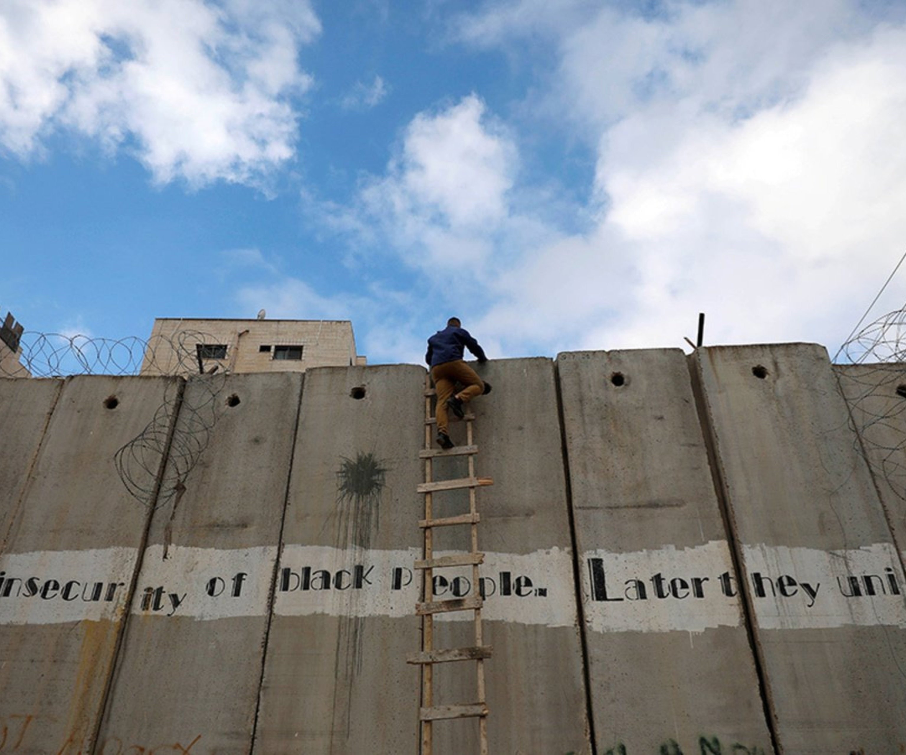 شاب فلسطيني يتسلق الحاجز الإسرائيلي في الضفة الغربية المحتلة. شاب فلسطيني يتسلق الحاجز الإسرائيلي في الضفة الغربية المحتلة.