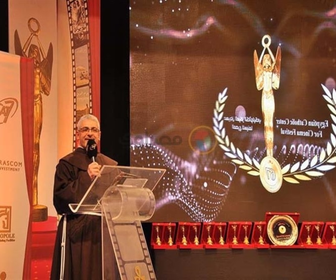 الأب "دانيال" وخلفه شعار المهرجان الأب "دانيال" وخلفه شعار المهرجان