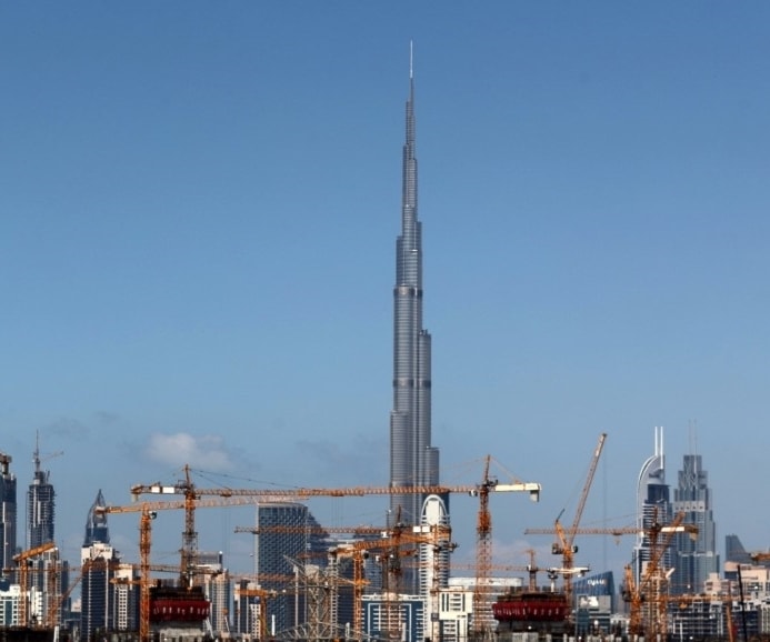 رافعات في موقع بناء مقابل برج خليفة في الإمارات (أ.ف.ب) رافعات في موقع بناء مقابل برج خليفة في الإمارات (أ.ف.ب)