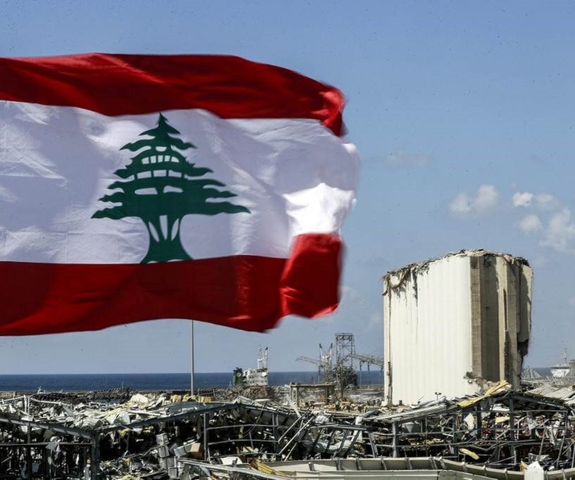 العلم اللبناني مرفوعاً قرب دمار مرفأ بيروت (أ.ف.ب) العلم اللبناني مرفوعاً قرب دمار مرفأ بيروت (أ.ف.ب)