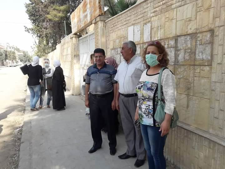 كادر مدرسة خليل الفراهيدي أمام مدرستهم