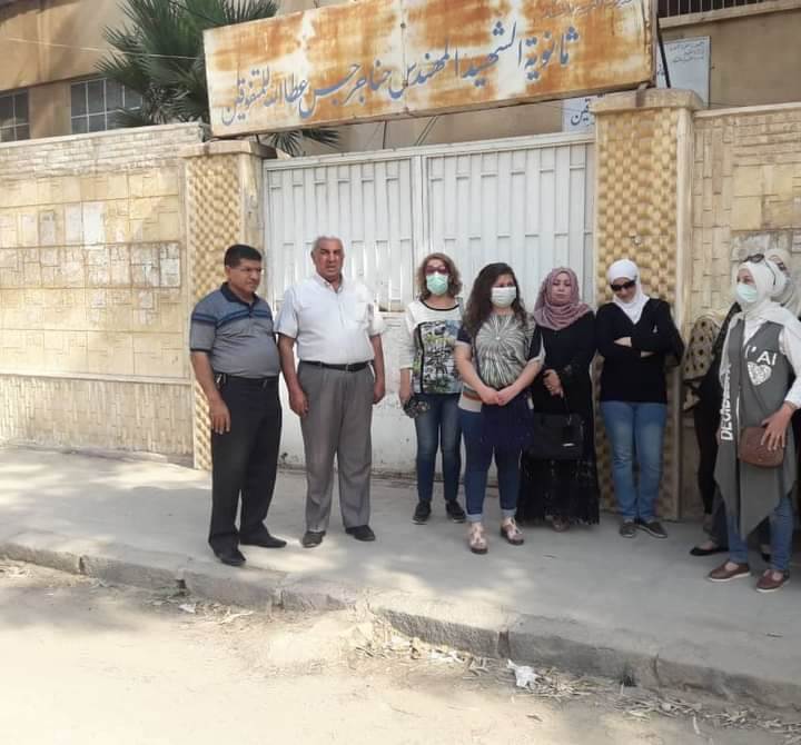 كادر مدرسة خليل الفراهيدي أمام مدرستهم