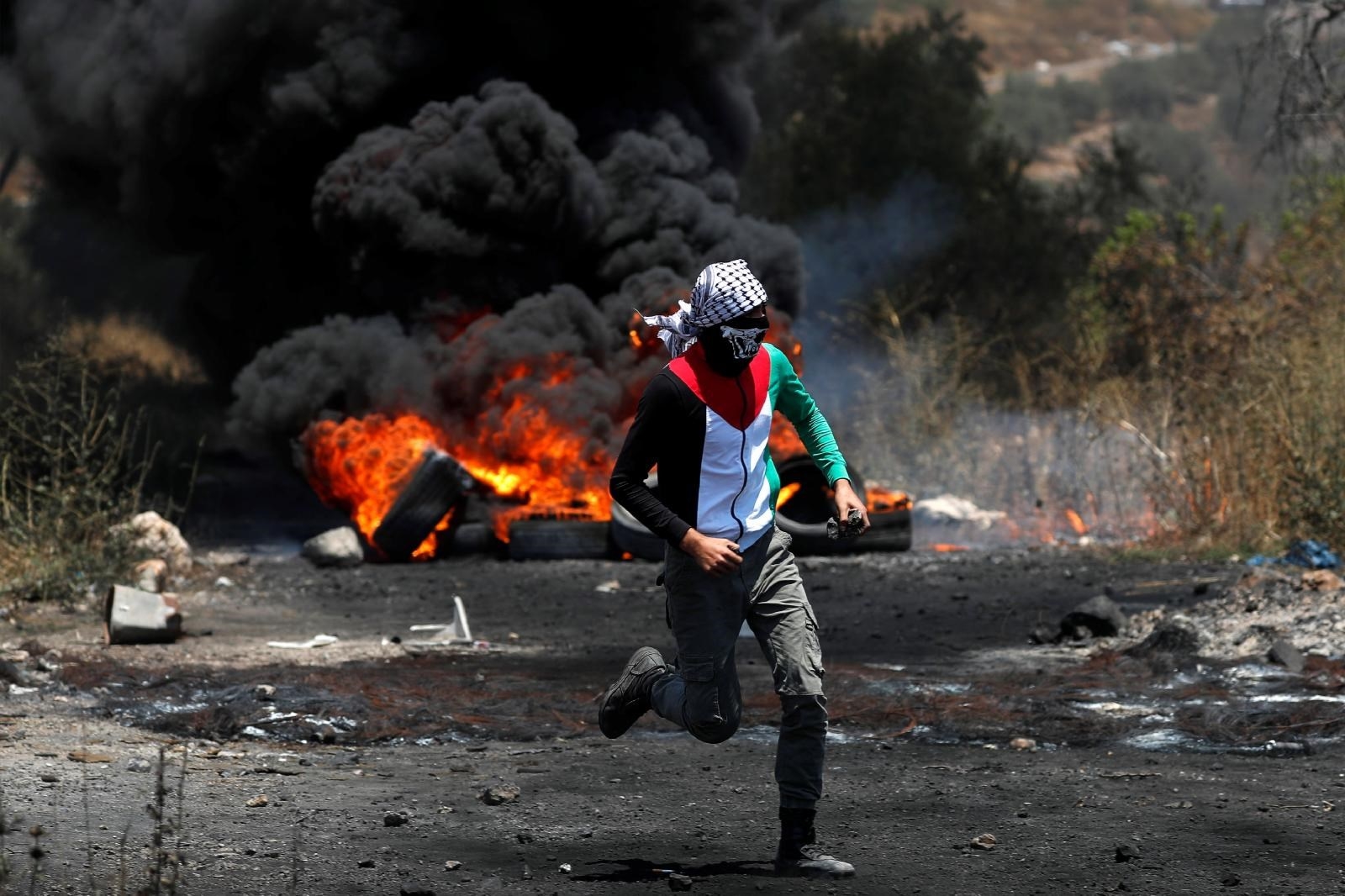 A Palestinian demonstrator runs during a protest against Israel's plan to annex parts of the occupied West Bank, near Nablus July 3, 2020.